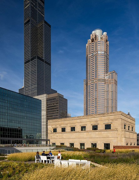 A group of people sitting on a bench in front of a building.